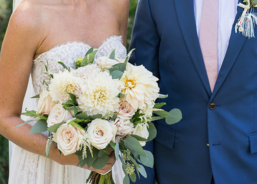 bride and groom holding bouquets blush and pale yellow wedding flowers