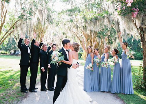 bride and groom kiss under spanish moss bridal party bouquets wedding florist