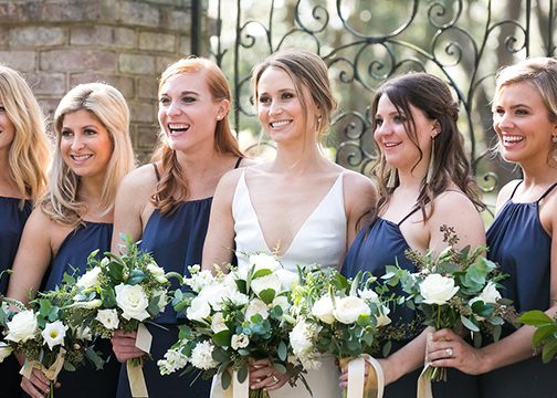 bride and bridesmaids in front of iron gate classic white floral bouquet wedding flowers