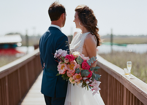 bride and groom on pier in Charleston sc wedding bouquet