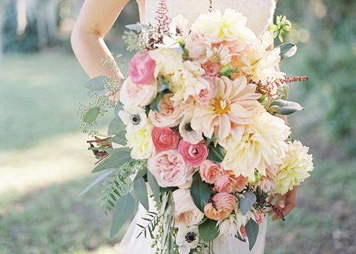 bride holding bridal bouquets pink peach yellow wedding flowers
